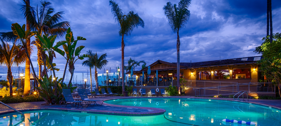 The BW+ Island Palms Hotel pool at night surrounded by palm trees