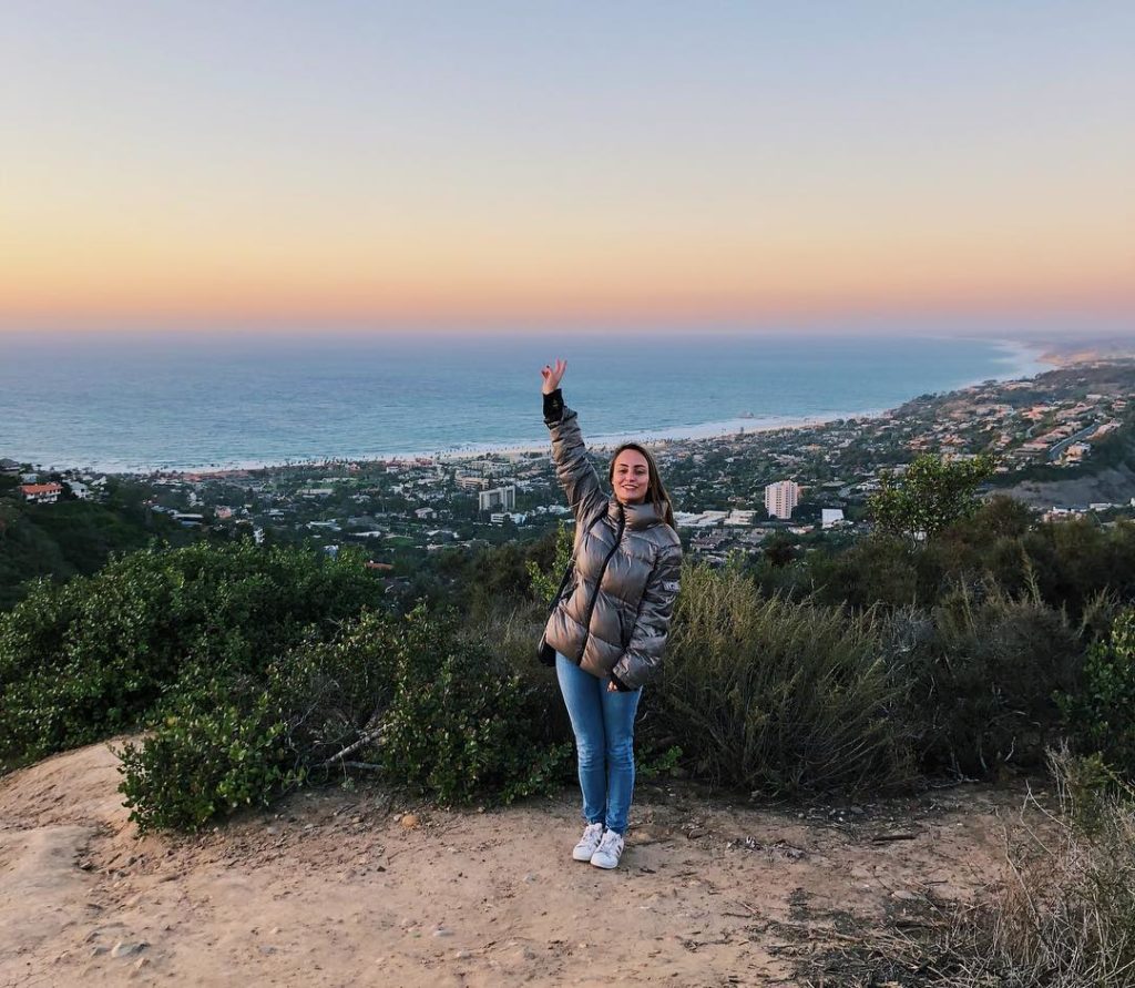 Girl standing in front of Sunset at Mount Soledad