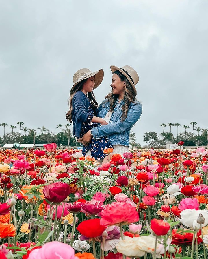 Mom and daughter standing in flowers
