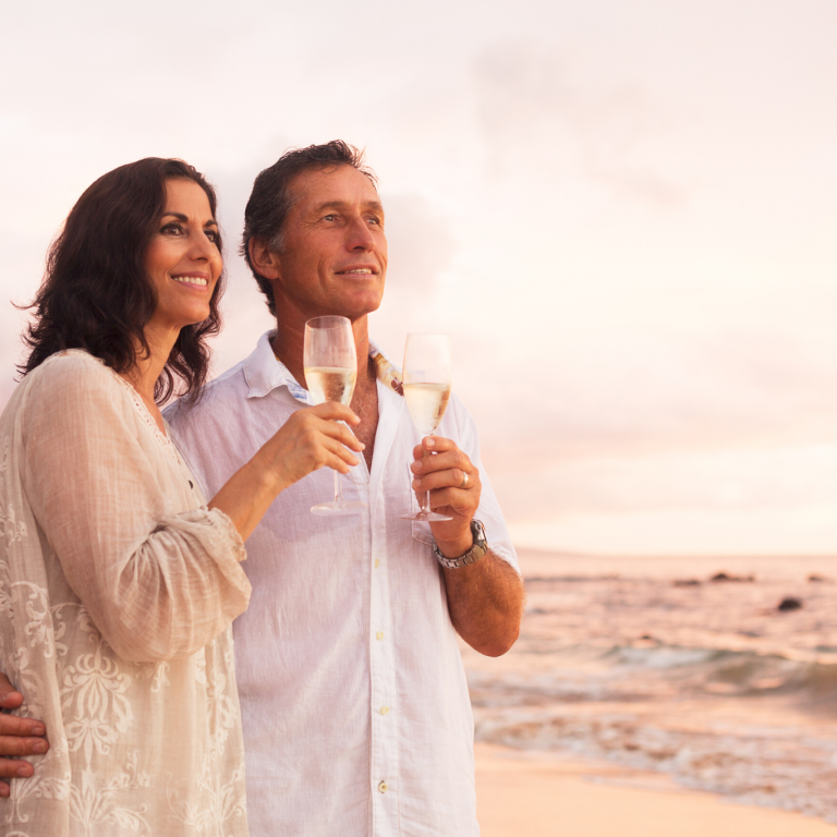 a couple drinking champagne on the beach