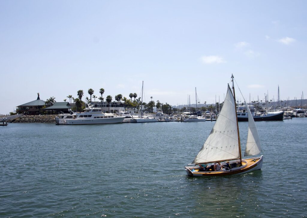 a sailboat with several yachts in the background