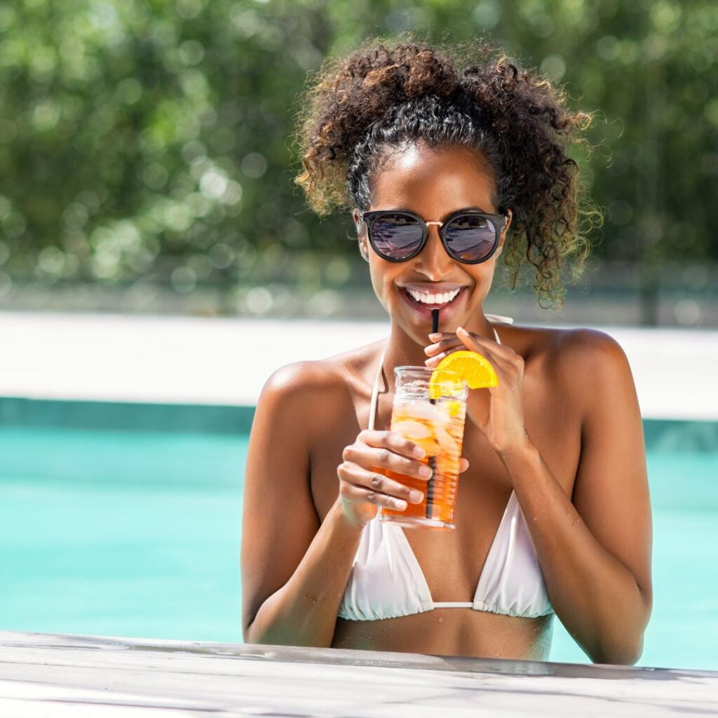 a woman in a swimming pool holding a cocktail