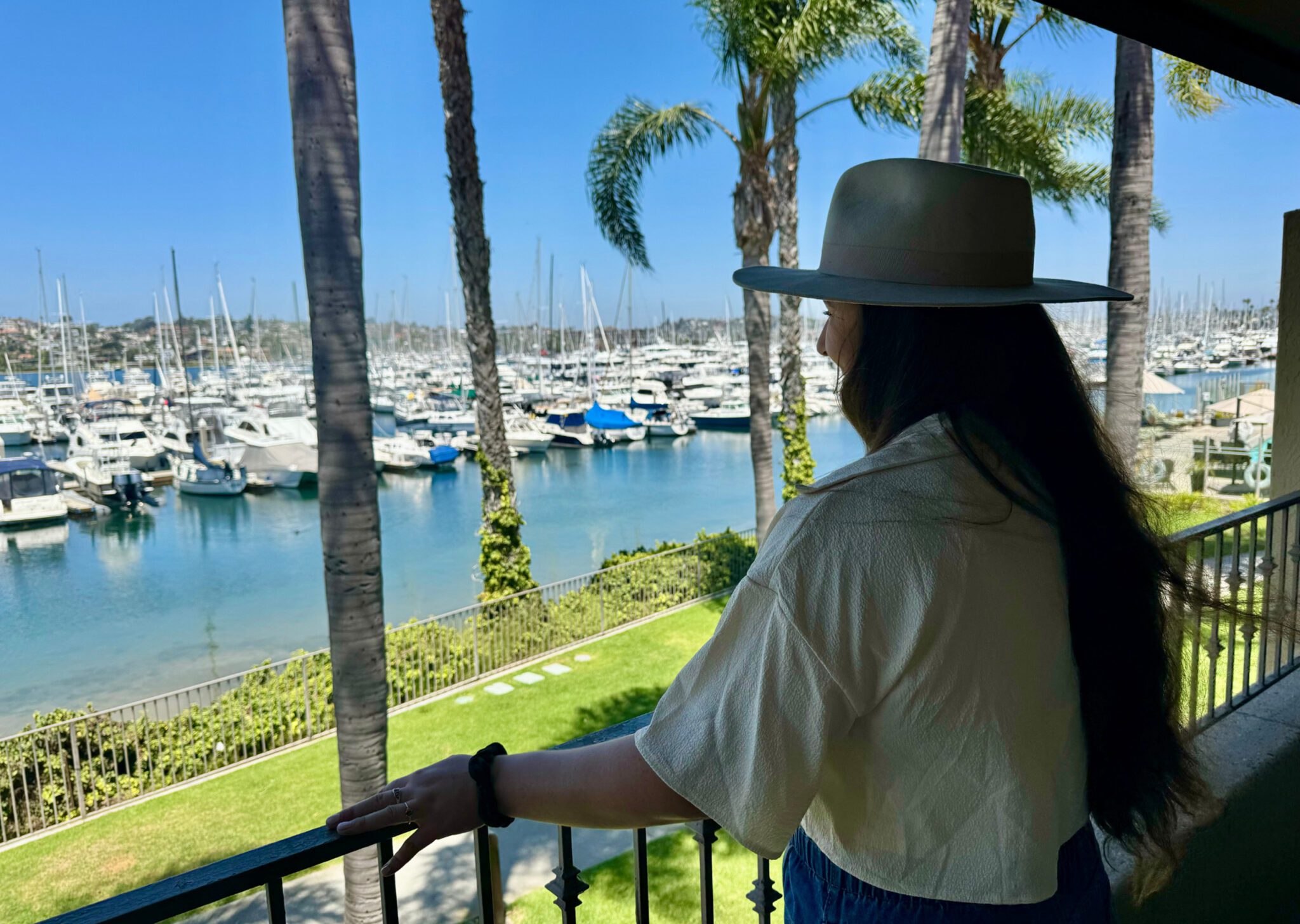 Woman looking out over marina on a balcony