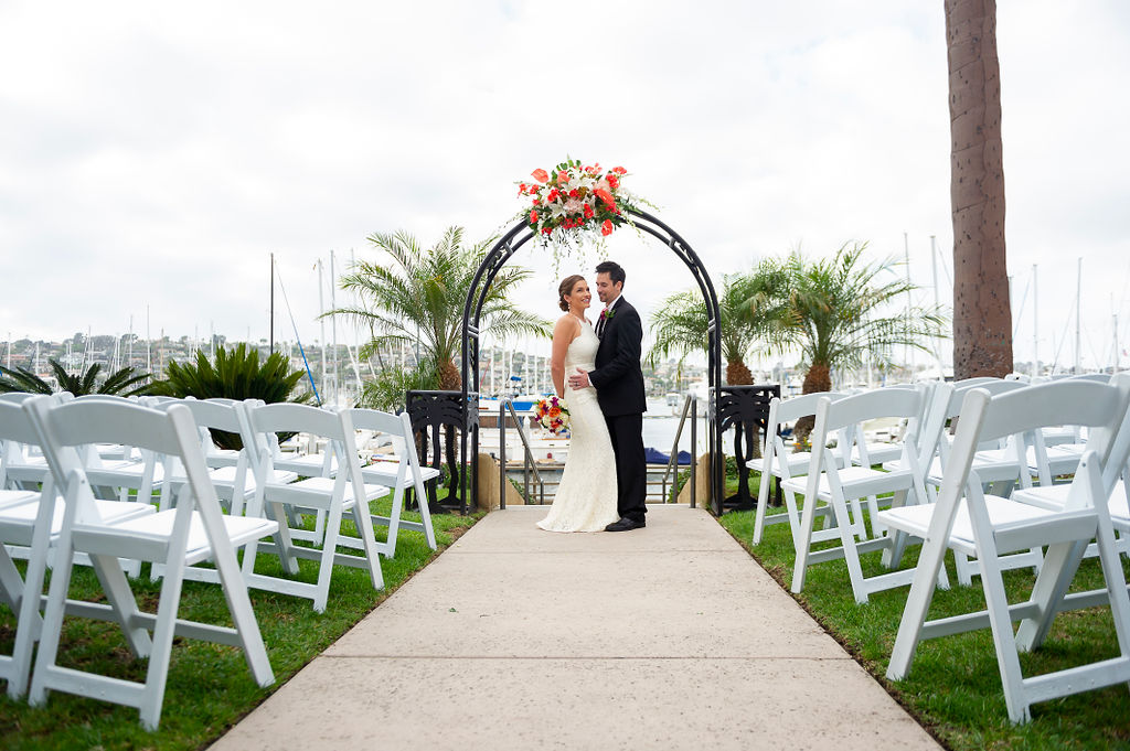 a bride and groom standing under an arch decorated with flowers