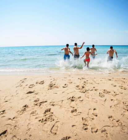 people running into the surf