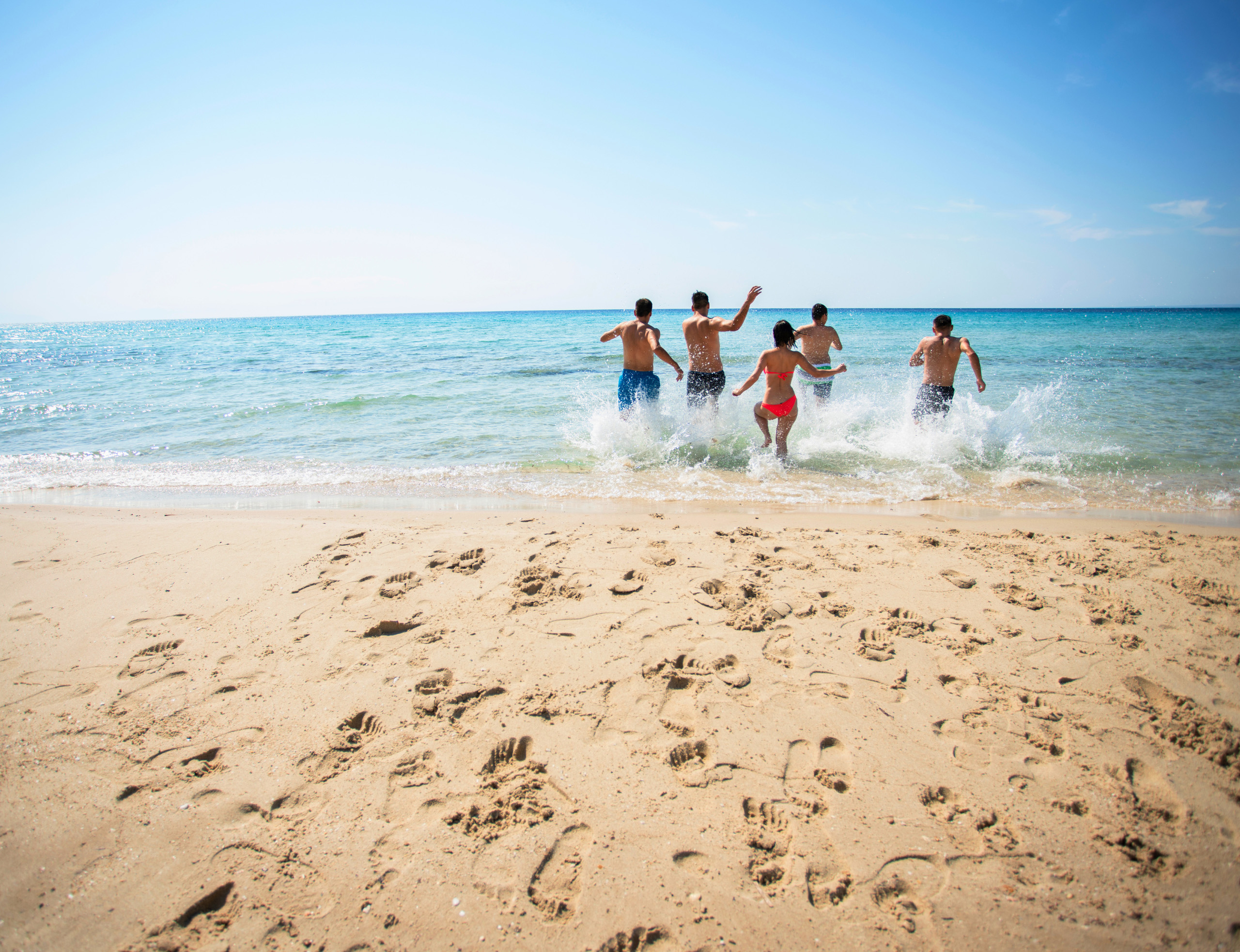 people running into the surf