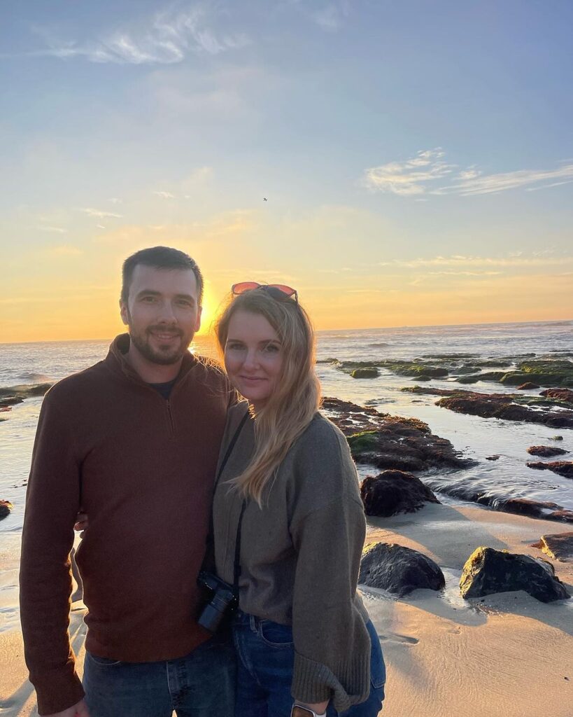 a couple on the beach at sunset