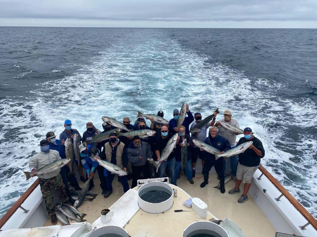 guests on a fishing boat holding up their catches