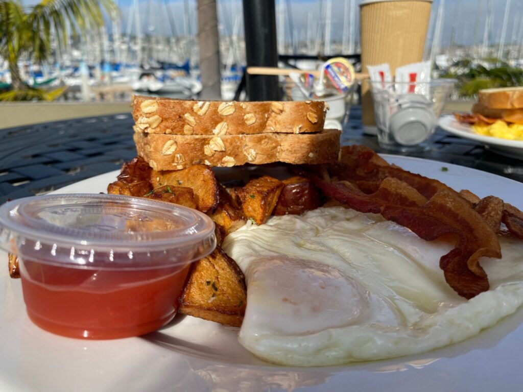 a large plate with eggs, toast, potatoes and bacon