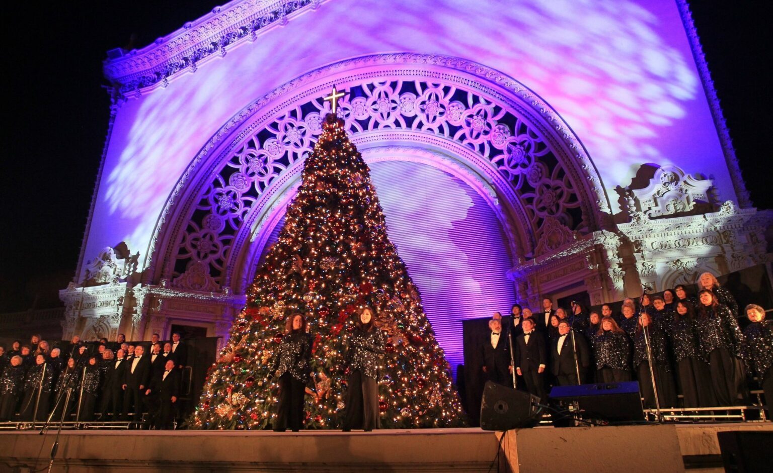 christmas tree on stage with people singing