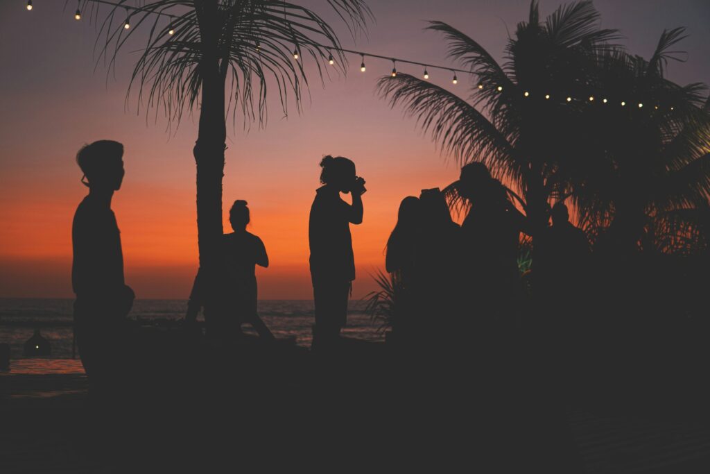 people drinking on the beach at sunset