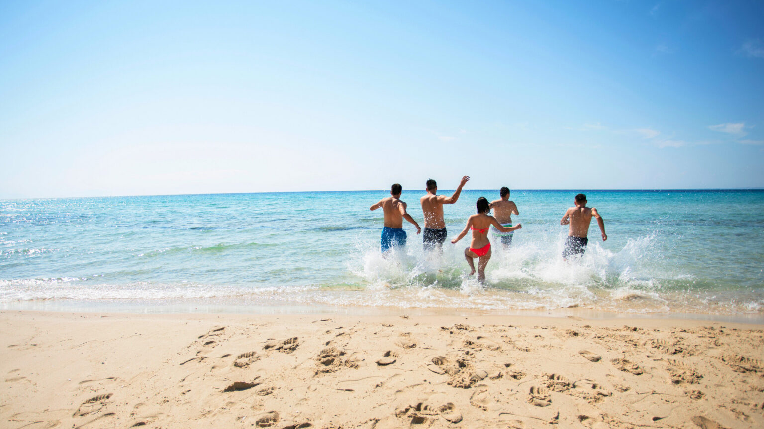 people running into the surf